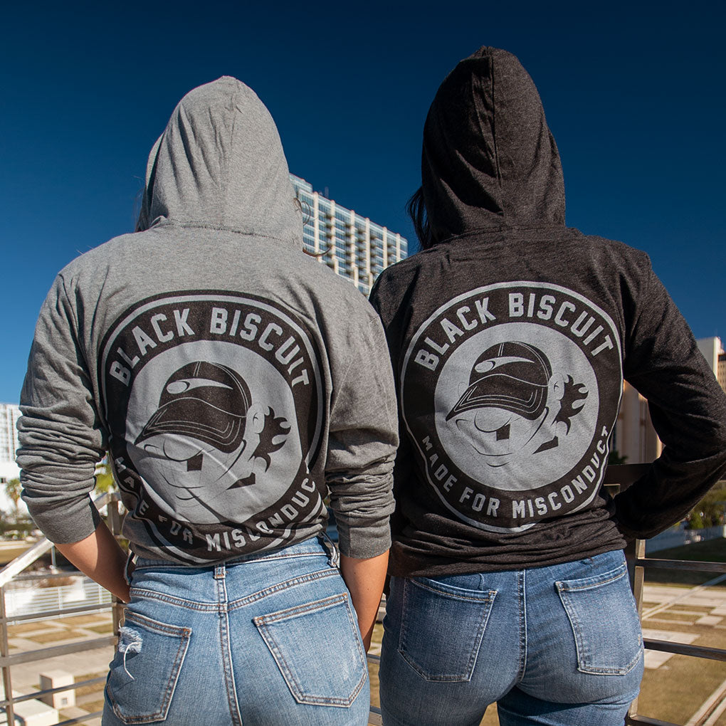 The backs of two individuals' hoodies, displaying the Black Biscuit logo