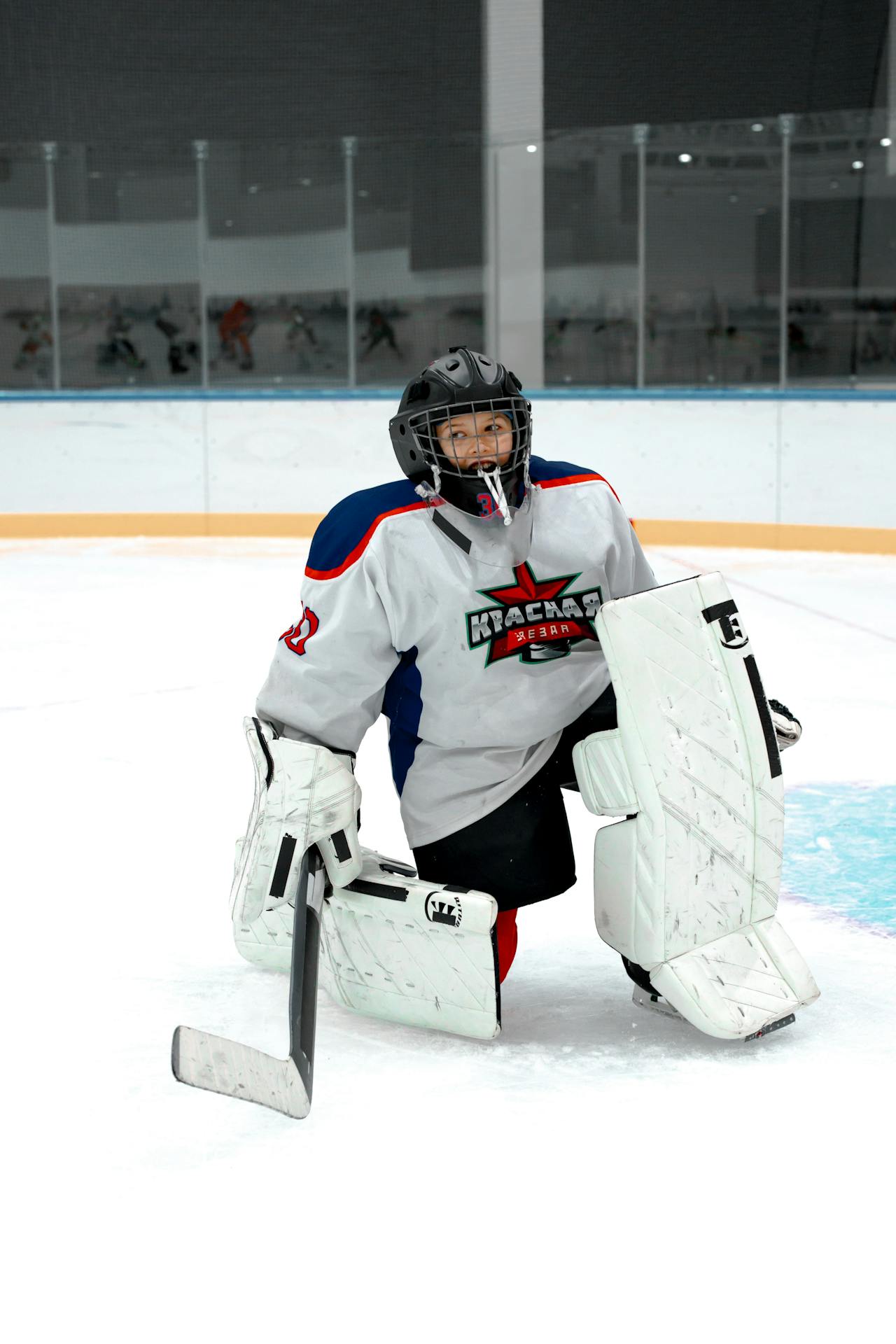 Child dressed in goalie gear on the ice